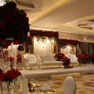 This reception stage exudes pure royalty. I used a classic all-white theme for the seating and backdrop, contrasted with dramatic deep-red rose arrangements. The result is a look that is both timeless and incredibly luxurious.