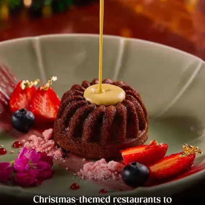 A stunning Christmas themed dessert. The sauce pour adds action, while the festive plating with berries and gold leaf makes it look like a special holiday treat. This is a perfect hero shot for a restaurant's Christmas menu.
