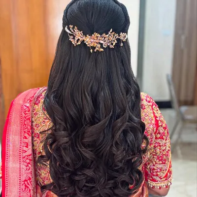 A stunning half-up hairstyle with deep, uniform curls and a beautiful gold and pearl hair accessory. This look is pure glamour.