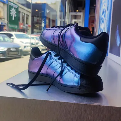 A pair of custom Adidas Superstars I painted with an iridescent, color-shifting effect. This photo was taken during a live painting event at an Adidas store, where I customized footwear for customers on the spot.