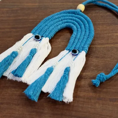 My blue rainbow car charm with evil eye details. It's a beautiful and protective accessory for your car, handcrafted with macrame.