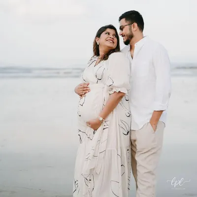 A beautiful, serene moment from a maternity shoot on the beach. The makeup is soft, natural, and radiant, designed to enhance her glow and look beautiful in the soft, natural light.