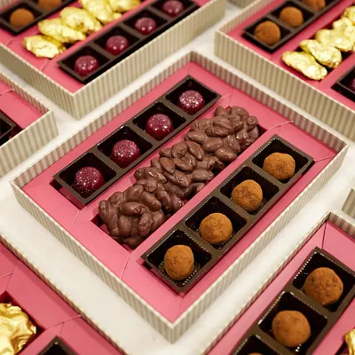 Elevate your corporate gifting with our bespoke chocolate boxes. This arrangement features an assortment of our Belgian truffles, chocolate almond bark, and gold-wrapped rochers.
