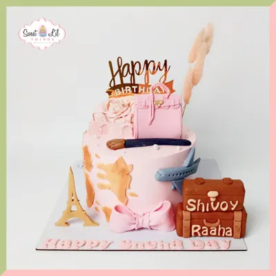 A dream cake for a globetrotting fashionista. This pink creation is adorned with a fondant handbag, an Eiffel Tower, an airplane, and personalized luggage, combining travel and luxury.