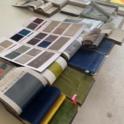 The design process starts with a sea of possibilities. Here, our table is covered with fabric swatch books as we curate the perfect color and texture palette for a new home.
