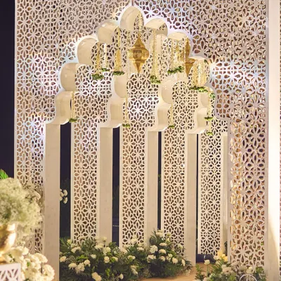 The entrance to the Sufi night featured a grand, multi-layered arch against a backdrop of intricate jaali screens. Hanging brass lanterns and floral details added to the Mughal-inspired aesthetic, creating a majestic first impression.