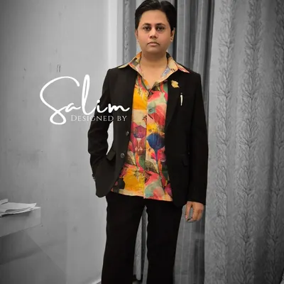A self-portrait wearing one of my own designs. A classic black suit paired with a vibrant, abstract-painted shirt for a pop of color and personality.