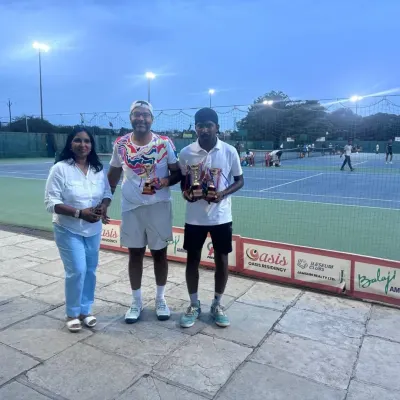 Coach Raju Muthukrishnan and a student with their trophies from the ITF World Masters Tour. We believe in a player-coach model where our mentors are also active, successful competitors.