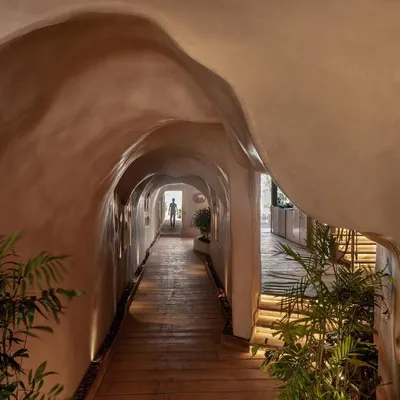 The entrance to Dubki in Goa was designed to feel like discovering a hidden cave. The fluid, ferro-cement walls and warm, low-level lighting guide you through a tunnel that opens up to the expansive view of the ocean, creating a dramatic sense of arrival.