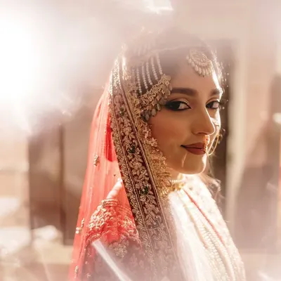A stunning bridal portrait using creative flare to create a dreamy, ethereal glow. This artistic approach highlights the bride's beauty and the magic of the moment.