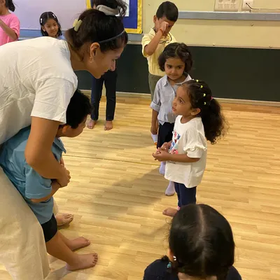 A quiet moment of guidance and connection during a rehearsal. We believe in nurturing our little stars, giving them the individual attention they need to build confidence and understand their role within the larger group.