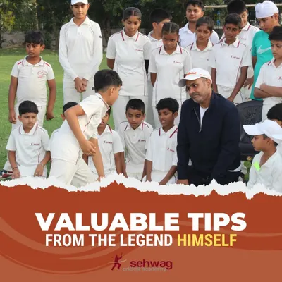 Virender Sehwag engages in a personal coaching moment with a young player. This direct feedback is crucial for developing a strong technical foundation and building self-belief.