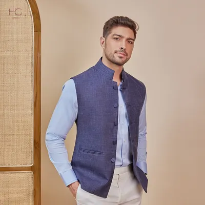 This is my modern twist on a classic style. A tailored navy Nehru vest is layered over a light blue shirt, creating a look that is perfect for festive occasions or formal events.