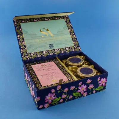 This deep blue box features a beautiful lotus pond design that continues on the inside. It includes space for the main invitation card and two matching jars for sweets, all tied together with a satin ribbon.