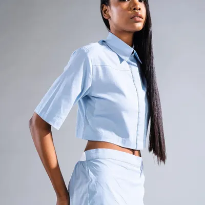 A full-length look showcasing exceptionally long, sleek hair paired with clean, minimalist makeup. This style emphasizes sharp lines and a polished finish for a modern fashion statement.