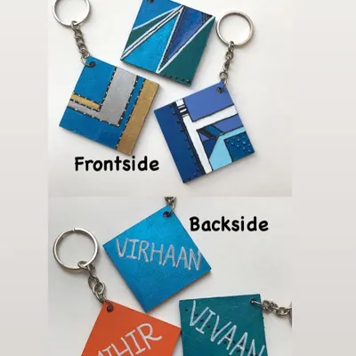 This shows the front and back of my personalised keychains for boys. The front features a cool, abstract geometric design, while the back is hand-painted with their name for a truly custom touch.
