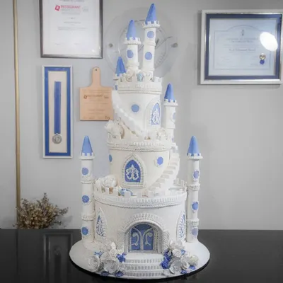 A truly regal creation, this multi-tiered castle cake with intricate piping and blue accents is perfect for a grand, fairytale celebration.