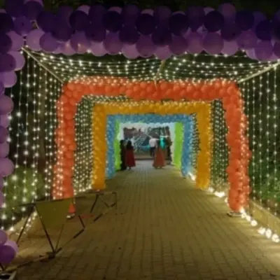 Make a grand entrance with this spectacular rainbow balloon tunnel. Lined with fairy lights, this installation creates an immersive and colorful walkway for guests at a large outdoor birthday party or event.