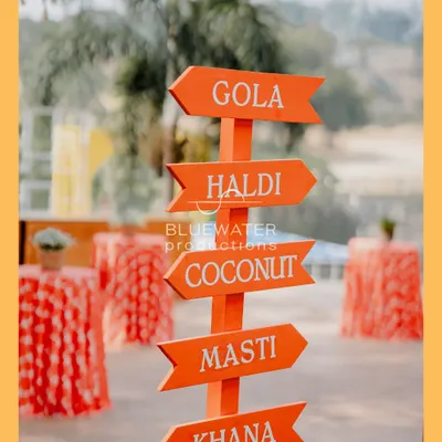 It's all about the fun and masti. We created this quirky directional sign for a Haldi event, pointing guests to all the important stations: Gola, Haldi, Coconut, Masti, and Khana.