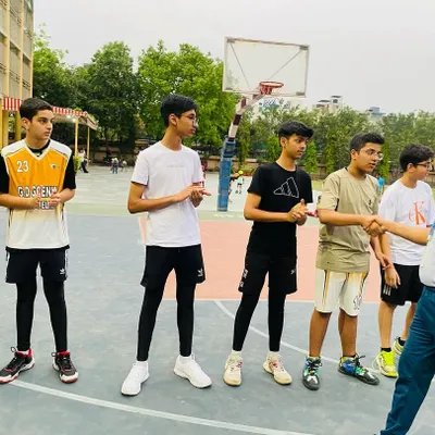 A coach gives instructions to the senior players before a match, discussing strategy and focus points.