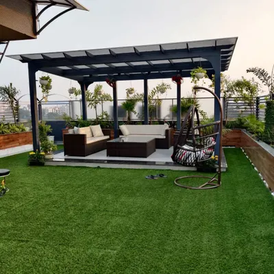 A complete terrace makeover with a pergola, outdoor furniture, and artificial lawn. This setup is perfect for hosting guests or enjoying a quiet evening outdoors.