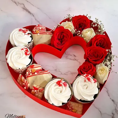 Our Valentine's Day heart hamper is the perfect romantic gift. This beautiful heart-shaped box is filled with fresh red and white roses, decadent cupcakes, and geometric white chocolate hearts.
