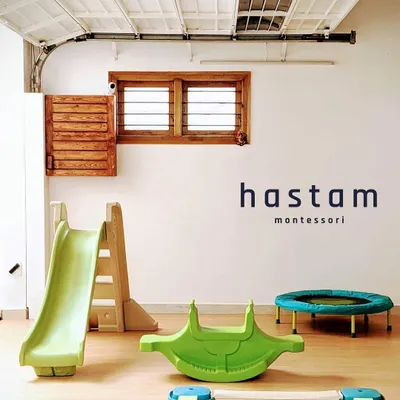 Our indoor play area is a space for joyful movement. It features a slide, a mini-trampoline, and a rocker, all on a soft floor, allowing children to safely develop their gross motor skills.