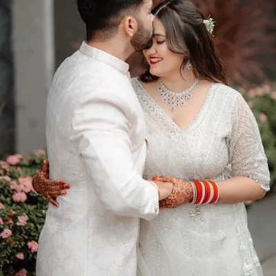 A tender forehead kiss, a classic and romantic moment from Utkarsh and Ruchika's engagement shoot. Their coordinated white outfits add to the elegance.