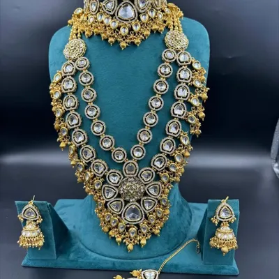 This is one of our grandest American diamond bridal sets available for rent. It features a heavy choker, a three-layer long necklace, and matching jhumka earrings and maang tikka for a truly unforgettable look.