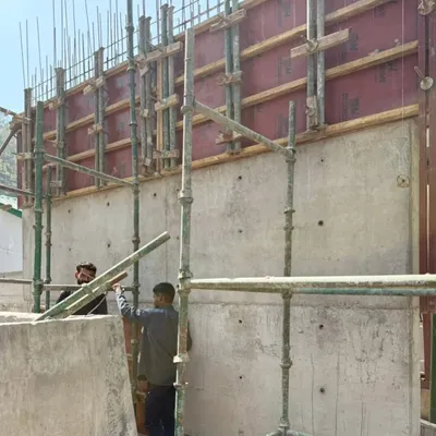 A freshly cast exposed concrete wall at our Himachal site. The formwork has just been removed, revealing the texture and tie-holes that become part of the final architectural finish.
