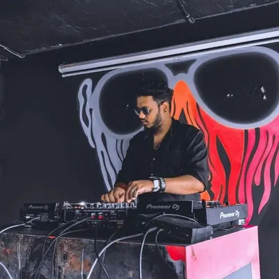 Spinning a set in a Bangalore club. The dark, moody lighting and cool graffiti art set the perfect stage for a night of deep house and hip hop music.