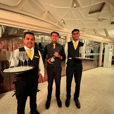 Our professional team at the Client Associates 20th-anniversary event. Dressed in smart uniforms, they are ready to serve champagne and welcome guests with a smile.