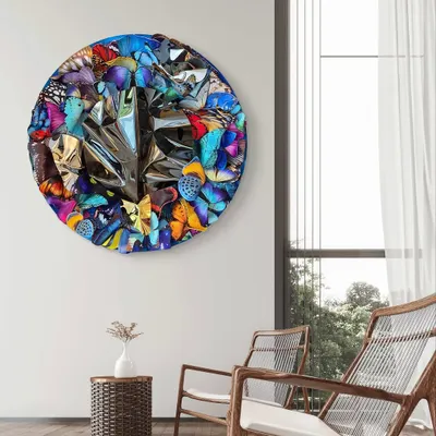 "Metamorphosis in Metal," a large circular wall installation. A vortex of colorful butterfly wings surrounds a center of crumpled, reflective steel, symbolizing the powerful energy at the heart of transformation.
