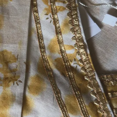 A close-up of the delicate gold lace and tie-dye inspired print on our yellow angarkha set. It’s these little touches of bling that make an outfit festive.