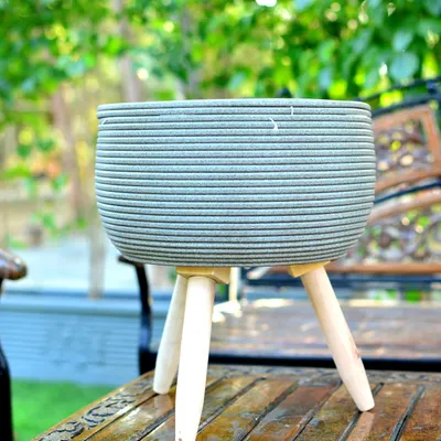 This textured planter with a mid-century modern wooden stand is one of my most popular items. It elevates the plant off the floor, giving it more presence and fitting perfectly with contemporary home decor.
