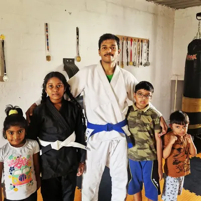 I believe martial arts education is essential for kids. Here I am with some of my young students in their BJJ gis. We offer both group and private classes to help them on their journey.