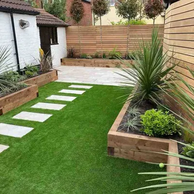This modern backyard is a great example of a complete garden transformation. I combined lush artificial grass with clean stone pavers and raised wooden planters to create a stylish, low-maintenance outdoor living space that looks perfect all year.