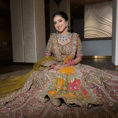 A bride seated in her magnificent multi-colored lehenga. I draped the dupatta to fall gracefully, complementing the grandeur of the skirt.