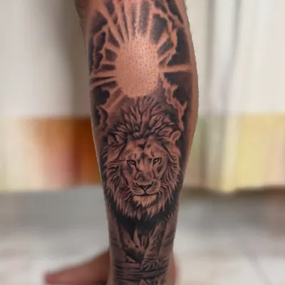 A majestic lion portrait on the calf, set against a rising sun. The detailed shading and powerful gaze capture the spirit of the "king of the jungle," symbolizing strength, courage, and leadership.