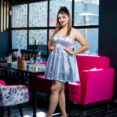 A full-length view of a fun and flirty party look. The silver sequin dress is paired with a high ponytail, bold red lips, and defined eyes, creating a perfect style for a birthday or cocktail party.