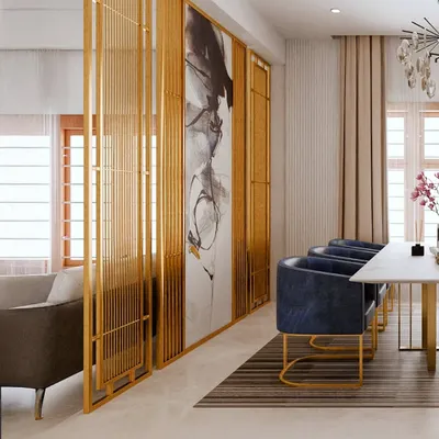 To create a sense of separation without closing off the space, I designed this elegant partition with gold-finished metal and abstract art. It beautifully frames the dining area, which features plush navy blue chairs and a sleek marble-top table for a contemporary, luxurious feel.