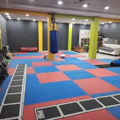 This is our dedicated matted zone. It's a versatile space for martial arts fitness, agility drills using the ladder, and floor exercises. The punching bag is always ready for a high-intensity cardio and striking session.