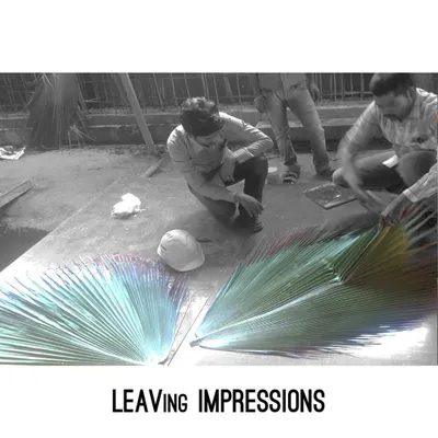 This image captures the process of creating our signature leaf-imprinted concrete. We carefully press large palm leaves into wet concrete, leaving behind a beautiful, natural texture that is truly one of a kind.