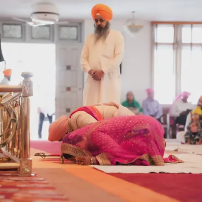 A moment of deep respect and prayer during an Anand Karaj ceremony. I capture these solemn moments from a low angle to emphasize the sanctity of the space.
