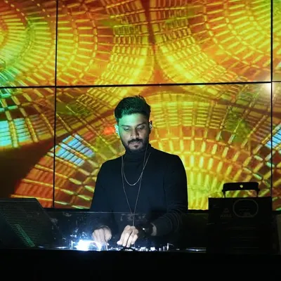 Focused on the mix, with a backdrop of spiraling, warm-toned geometric visuals on the LED screen. As a VDJ, I ensure the visuals are as dynamic and engaging as the progressive house and techno music I play.