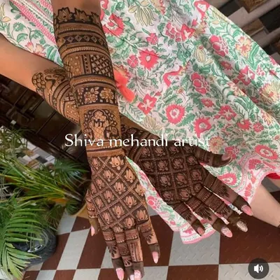 A modern take on a traditional pattern, this design features a full jaali (net) pattern made of lotus buds. The forearm includes an elephant motif and a personalized initial 'M'.