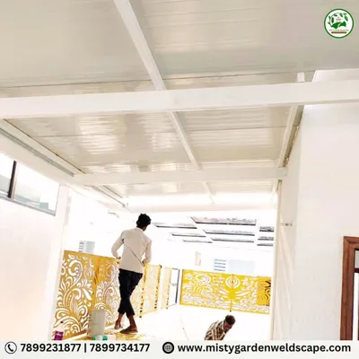 The installation of decorative CNC panels on a pergola at Natura Atavi. The golden-yellow panels add a vibrant and luxurious touch to the white structure.