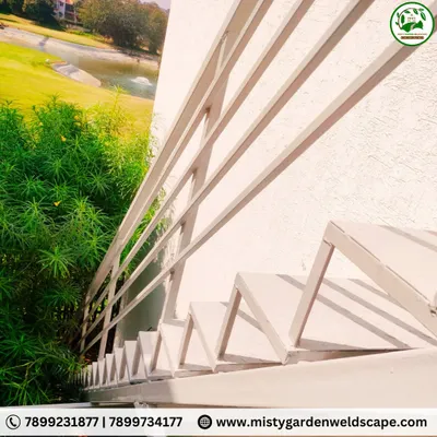 A sleek and modern metal staircase with a simple, clean railing design. This outdoor staircase at Prestige Augusta Golf Village provides access while maintaining a minimalist aesthetic that complements the lush green surroundings.