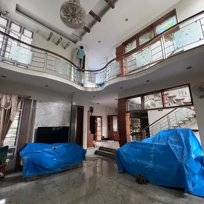 This is the beginning of a transformation in a large duplex home. You can see how we meticulously cover all furniture and flooring with protective sheets before starting any painting work on the high walls and ceilings.