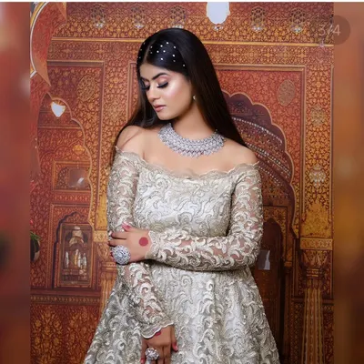 This elegant off-shoulder gown with intricate silver embroidery is perfect for a reception or engagement shoot. It pairs beautifully with our American Diamond jewellery.
